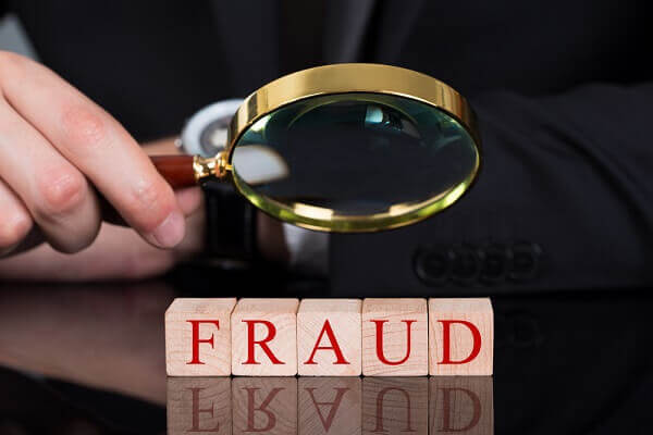 using magnifying glass to investigate fraud